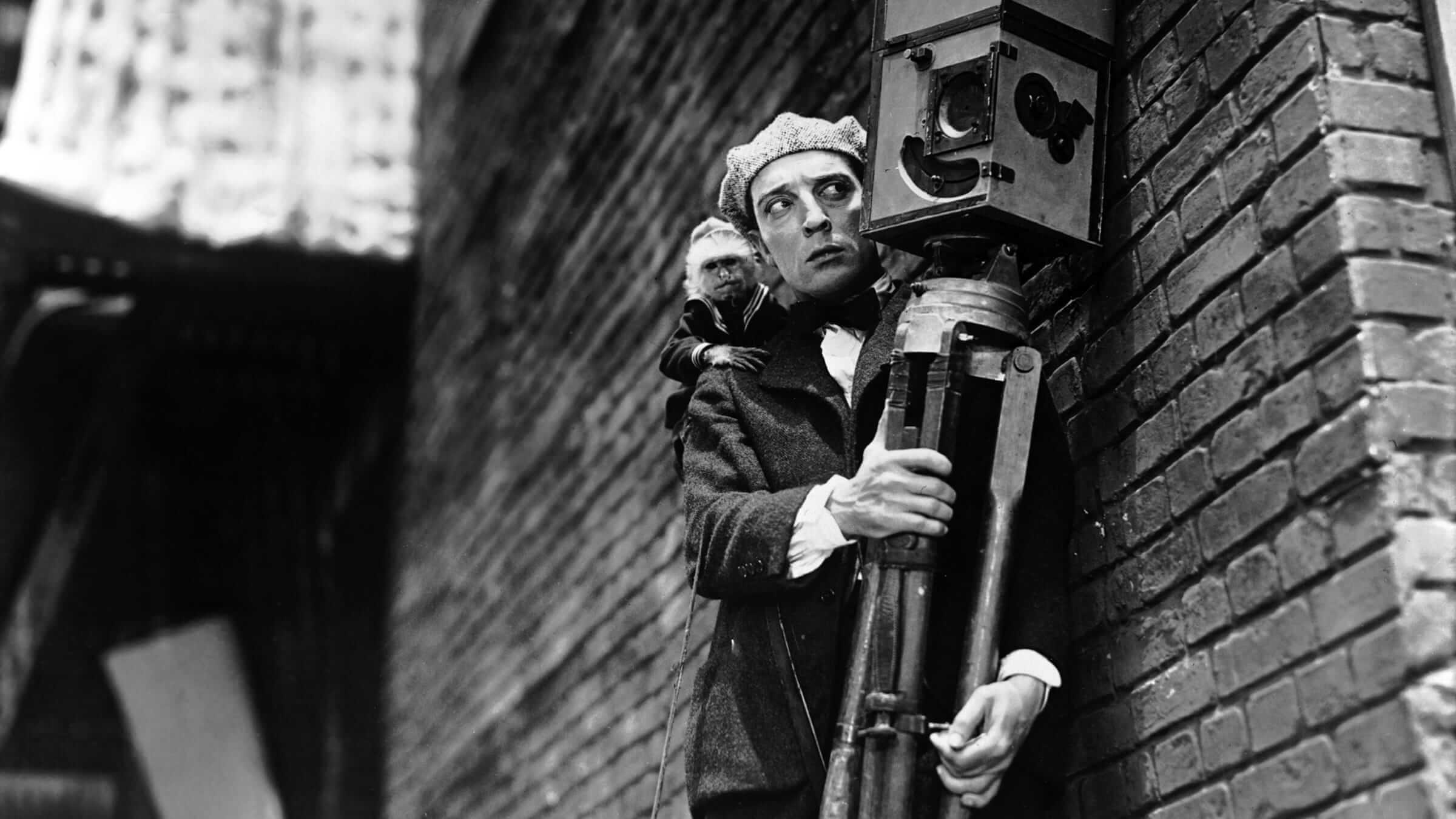 A man holding a movie camera and a monkey on his shoulder in 'Man with a Movie Camera,' The 10 Greatest Documentaries of All Time