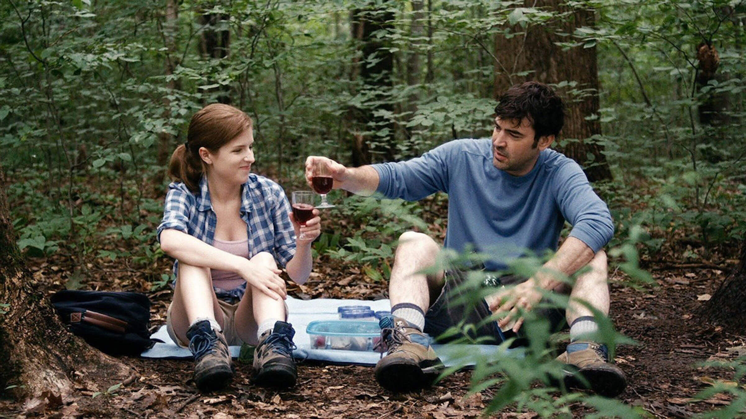 Jill (Anna Kendrick) and Chris (Ron Livingston) drinking wine in the woods in 'Drinking Buddies,' What Are Mumblecore Movies?