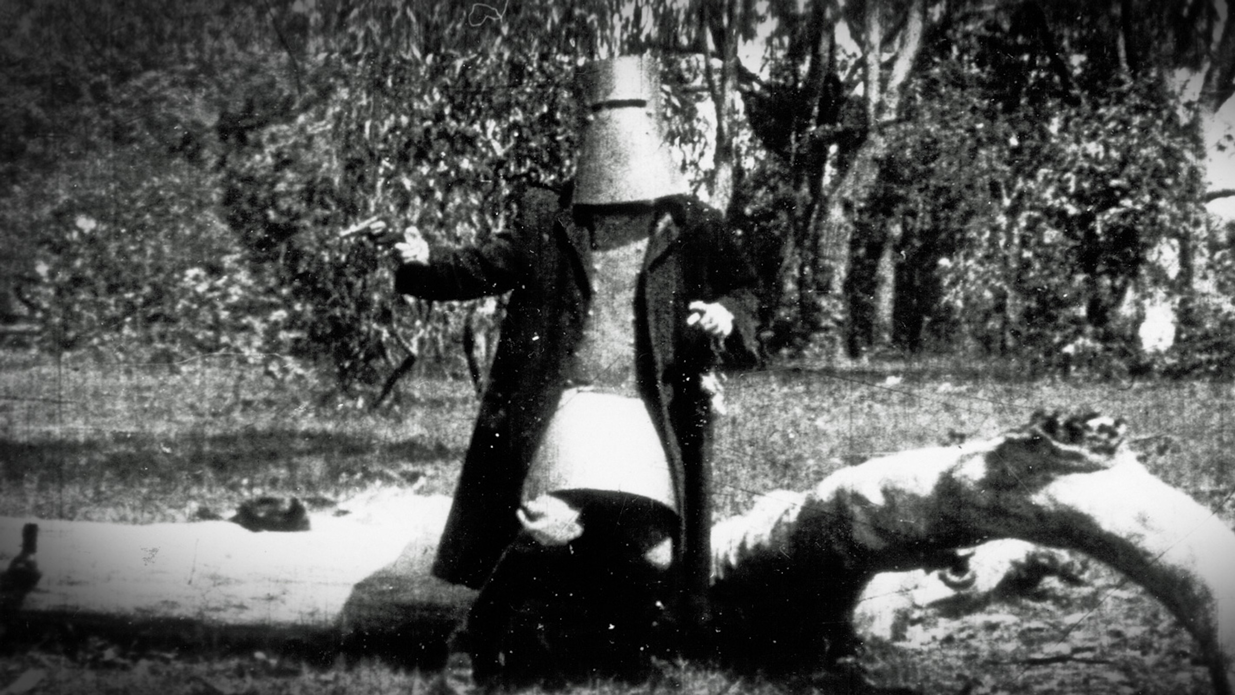 A gray scale still of a man wearing a bucket helmet as he fights back in 'The Story of the Kelly Gang,' What Was the First Feature Length Biopic?
