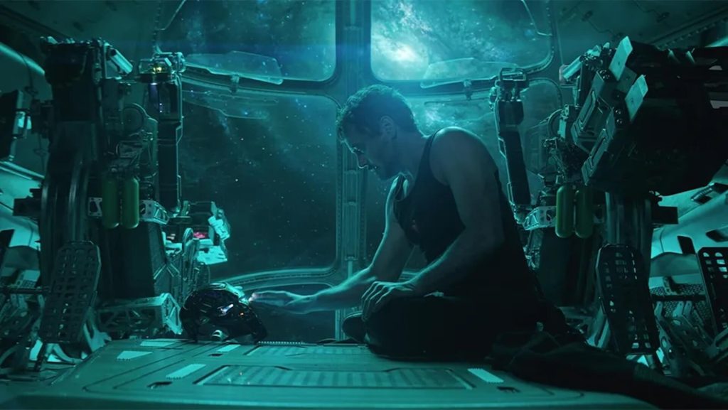 Tony Stark (Robert Downey Jr.) looking at his helmet while he floats through space.